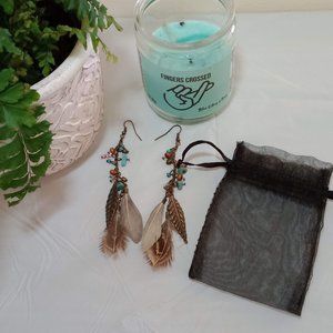 Feather earrings with gemstone accents and black satchel.
